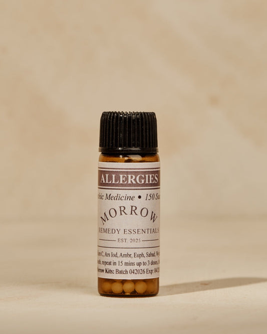 A small amber glass bottle of Fever Medicine 'Tomorrow Morning' essential oil with a black cap, set against a warm beige textured background.