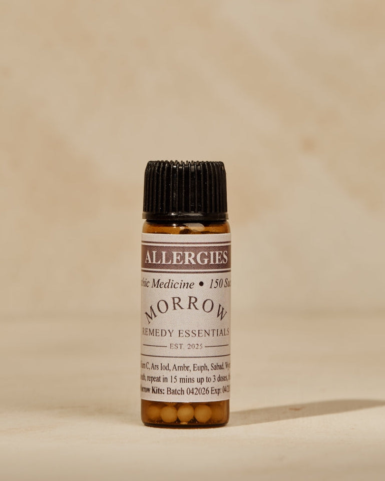 A small amber glass bottle of Fever Medicine 'Tomorrow Morning' essential oil with a black cap, set against a warm beige textured background.